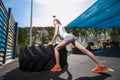 Fit girl with giant truck workout turning tire over.