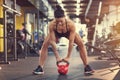 Fit girl in gym exercise using kettle bell weight