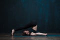 Fit girl practicing yoga asana against dark wall Royalty Free Stock Photo