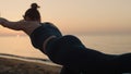 Fit girl practicing yoga pose on beach. Sporty woman training balance at dusk. Royalty Free Stock Photo