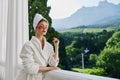 a fit girl in a white robe the balcony overlooks the mountains looking on the view