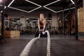 Fit gorgeouse woman is working out with battle ropes to keep fit Royalty Free Stock Photo