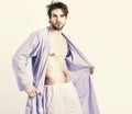 Fit guy with torso and six packs in blue bathrobe. Man with beard in blue dressing gown on white background. Royalty Free Stock Photo