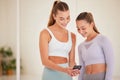 Fit, happy and athletic women laughing at funny social media posts on a phone before exercising together. Young athletes