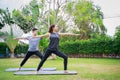 Fit happy people working out outdoor. Asian couple exercising together on a yoga mat at home garden. Family outdoors. exercise at Royalty Free Stock Photo