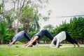 Fit happy people working out outdoor. Family Asian parent and child daughter exercising together on a yoga mat at home garden. Royalty Free Stock Photo