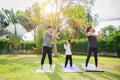 Fit happy people working out outdoor. Family Asian parent and child daughter exercising together on a yoga mat at home garden. Royalty Free Stock Photo