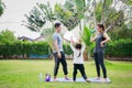 Fit happy people working out outdoor. Family Asian parent and child daughter exercising together on a yoga mat at home garden. Royalty Free Stock Photo