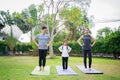 Fit happy people working out outdoor. Family Asian parent and child daughter exercising together on a yoga mat at home garden. Royalty Free Stock Photo