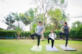 Fit happy people working out outdoor. Family Asian parent and child daughter exercising together on a yoga mat at home garden. Royalty Free Stock Photo