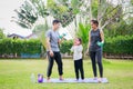 Fit happy people working out outdoor. Family Asian parent and child daughter exercising together on a yoga mat at home garden. Royalty Free Stock Photo