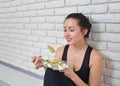 Fit healthy woman in sportswear eating a fresh salad after fitness workout. Royalty Free Stock Photo