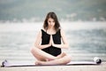 Fit healthy woman stretching on yoga mat on beach seaside, doing exercise abdominal crunches, training and lifestyle. Royalty Free Stock Photo