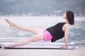 Fit healthy woman stretching on yoga mat on beach seaside,doing exercise abdominal crunches,training and lifestyle. Royalty Free Stock Photo