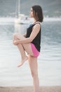 Fit healthy woman stretching on yoga mat on beach seaside,doing exercise abdominal crunches,training and lifestyle. Royalty Free Stock Photo