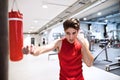 Fit hispanic man in gym punching boxing bag