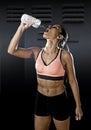 Fit latin sport woman in fitness clothes drinking water tired during training workout in healthy lifestyle