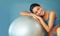 The fit life. a sporty young woman leaning against a pilates ball. Royalty Free Stock Photo