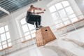 Fit male athlete doing box jump exercise in light hall Royalty Free Stock Photo