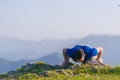 Fit male athlete doing push ups at the edge of a cliff while enjoying the amazing view