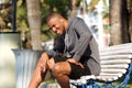 Fit male runner sitting on bench and listening music Royalty Free Stock Photo