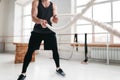 Strong fitness sportsman using training ropes for exercise at gym