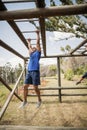 Fit man climbing monkey bars during obstacle course Royalty Free Stock Photo