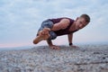 Fit man doing the eight angle pose on a rock Royalty Free Stock Photo