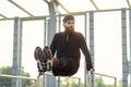 Fit man doing triceps dips on parallel bars at park exercising outdoors Royalty Free Stock Photo