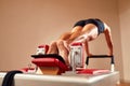 Fit man doing a lunge stretch yoga pilates exercise to strengthen and tone his muscles using a reformer in gym. Health Royalty Free Stock Photo