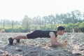 Fit man doing pank exercise during training workout on beach in summer. Royalty Free Stock Photo