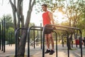 Fit man doing triceps dips on parallel bars at park exercising outdoors Royalty Free Stock Photo