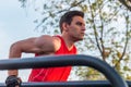 Fit man doing triceps dips on parallel bars at park exercising outdoors Royalty Free Stock Photo