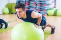 Fit man exercising with fit ball workout out arms Exercise training triceps and biceps doing push ups.