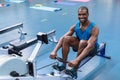 Fit man exercising on rowing machine in fitness center Royalty Free Stock Photo