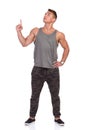 Fit Man In Gray Tank Top And Camo Pants Looking Up And Pointing