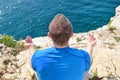 A fit man in the Lotus position on a seashore. Young fitness man doing yoga outdoors.