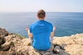 A fit man in the Lotus position on a seashore. Young fitness man doing yoga outdoors.