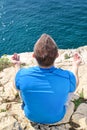 A fit man in the Lotus position on a seashore. Young fitness man doing yoga outdoors.