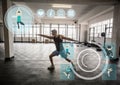 Fit man performing stretching exercise in gym against fitness interface in background