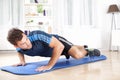 Fit Man Planking on Mat While Lifting One Leg