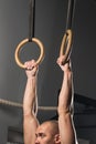 Fit man pulling up on gymnastic rings. Royalty Free Stock Photo