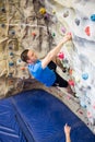 Fit man rock climbing indoors Royalty Free Stock Photo