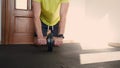 A fit man trains with an abdominal roller wheel - closeup from the front. Man using ab wheel at home. Static 4K footage