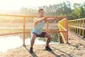 Fit man warming up doing squats stretching arms forward outdoors. Royalty Free Stock Photo
