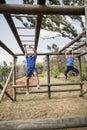 Fit man and woman climbing monkey bars during obstacle course Royalty Free Stock Photo