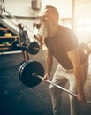 Fit mature man straining to lift weights in a gym