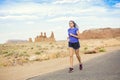 Fit middle-aged woman running along a paved trail in the scenic desert