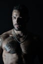 Fit model with tattoo design on skin. Bearded man with tattooed chest. Man with muscular torso. Sportsman or