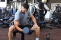 Fit and muscular man doing biceps workouts with dumbbells in gym, copy space Royalty Free Stock Photo